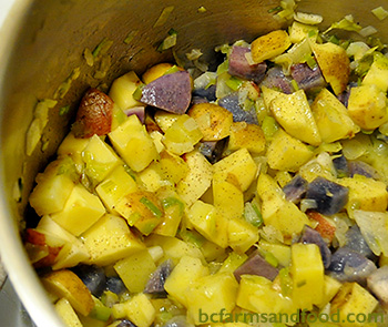 Potatoes, leeks and onions sauté in a large pot. Using a mix of potato varieties makes adds flavour to Potato, Leek and Ham soup.